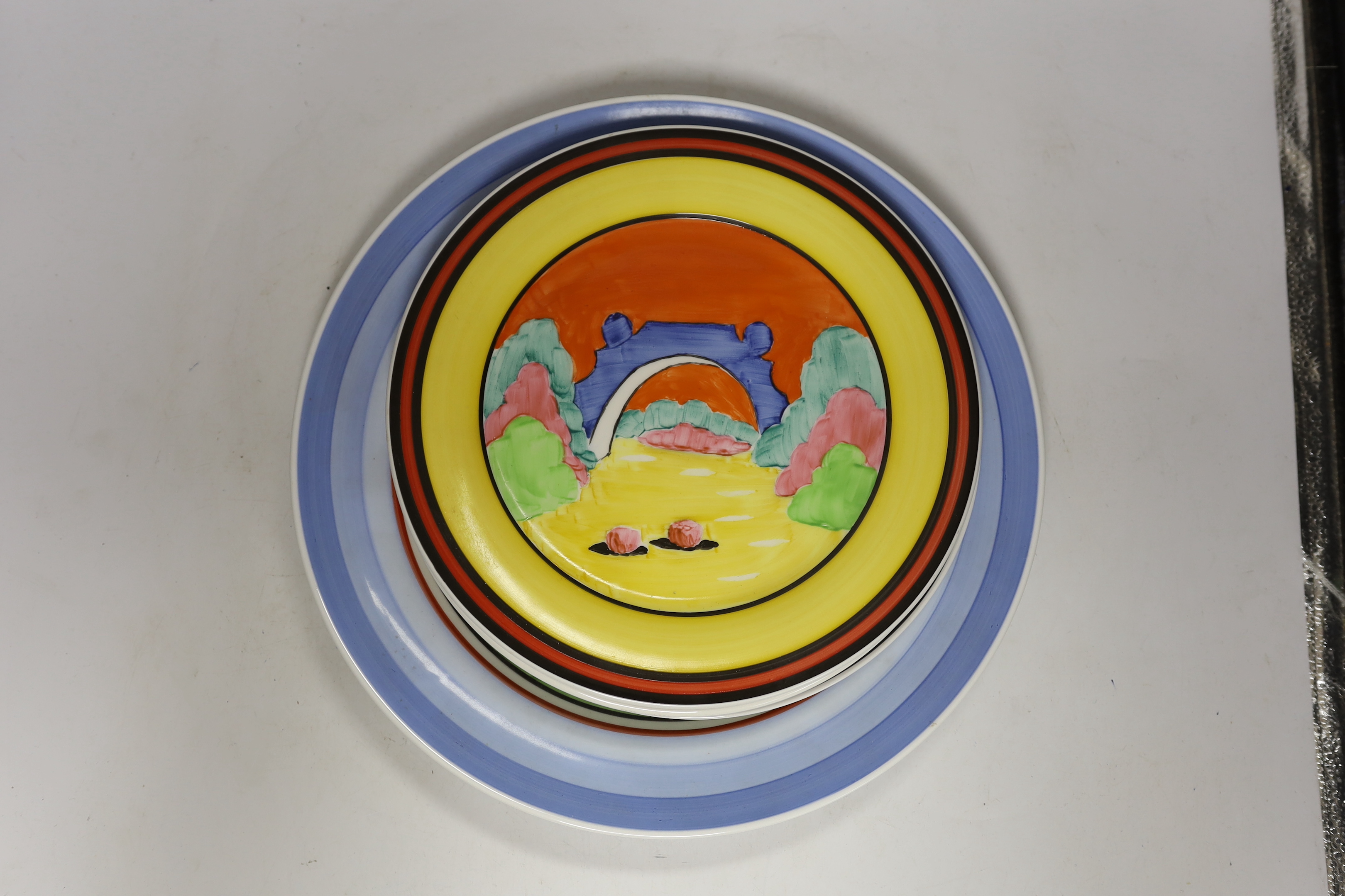 Four Clarice Cliff style plates, a similar vase and a jar and cover, tallest 31cm